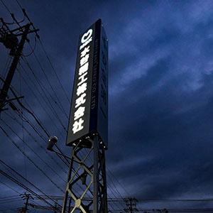 既存鉄塔にアルミ枠パネル看板　象嵌文字内照式で昼間の文字は黒に見えます。　三重県桑名市　工場看板