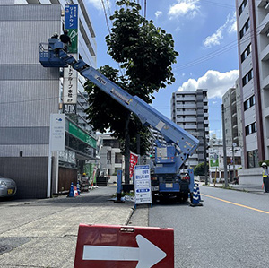 高所作業車での突出看板の点検・改装作業　道路使用許可申請をして交通誘導員が必要となる場所です。　愛知県名古屋市中区